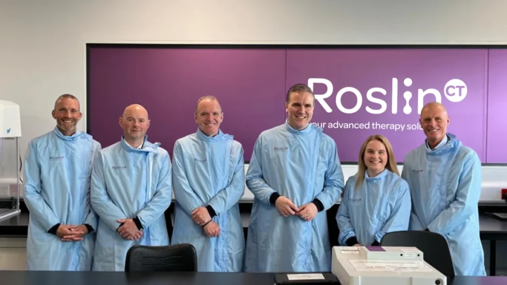 Six people in laboratory gowns at a RoslinCT facility in Edinburgh